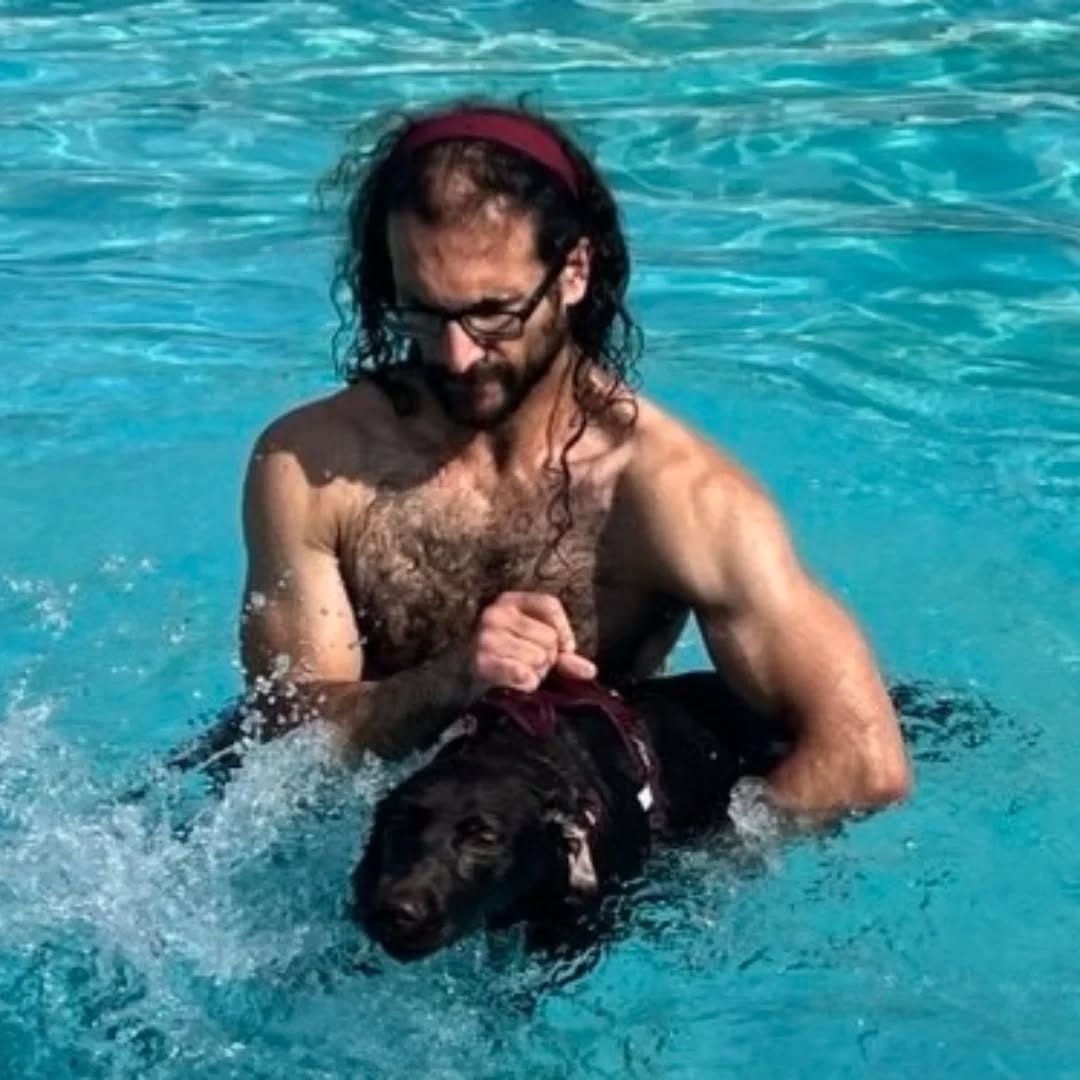 My lab in a pool with my husband
